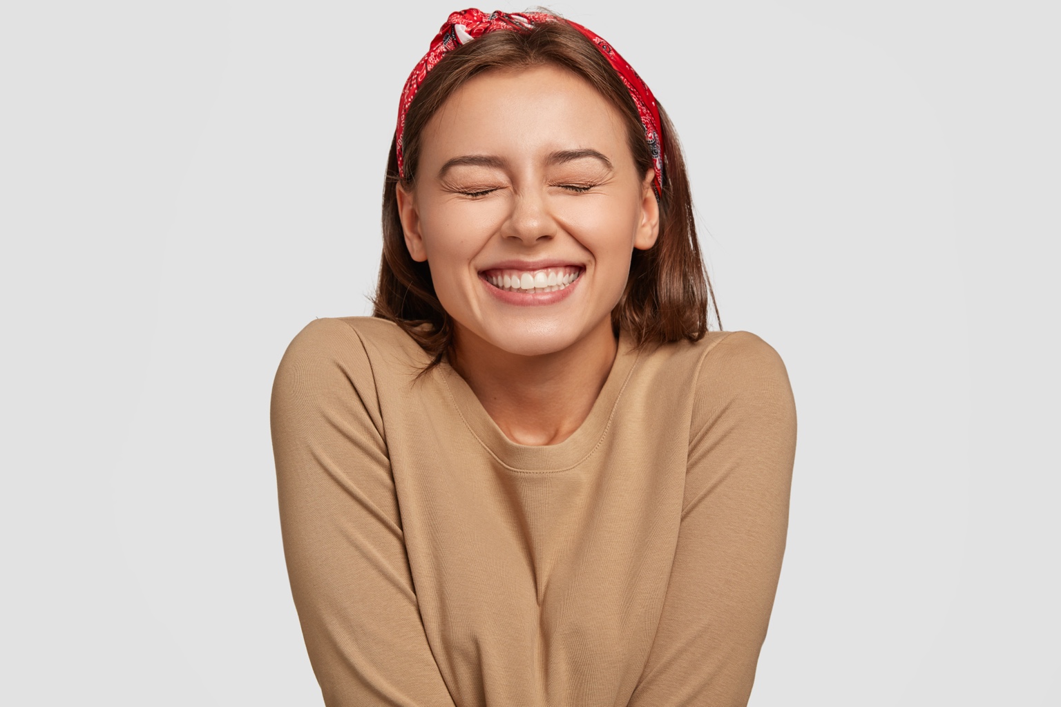 Fotografía ilustrativa de una mujer sonriendo con los ojos cerrados